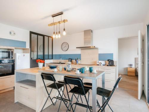 a kitchen with a large island with four chairs at Holiday Home Bol d'Air by Interhome in Ploubalay