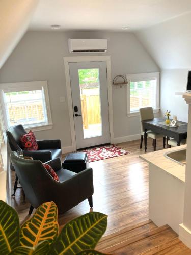 a living room with chairs and a table and a dining room at The Red House Fredericton in Fredericton