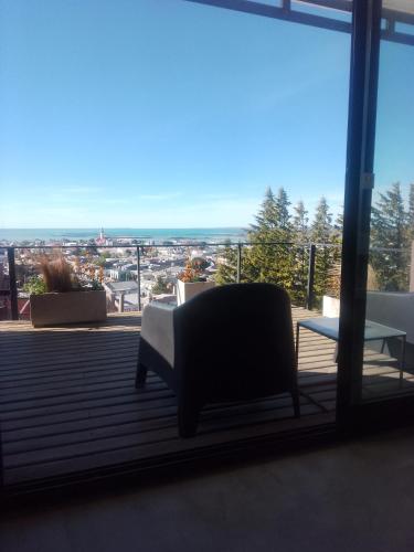 a chair sitting on a balcony with a view at HOMU DEP - Vista al mar in Puerto Deseado
