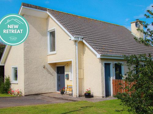 una casa con un nuevo letrero de retirada delante de ella en Holiday Home Dunmore Villas Holiday Home No 1 by Interhome, en Dunmore East