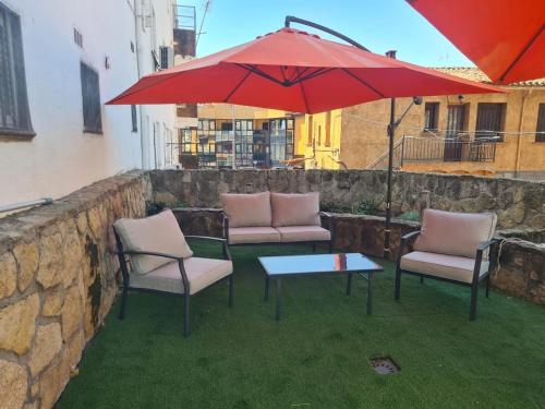 a patio with two chairs and a table and an umbrella at Tu Capricho in Piedralaves