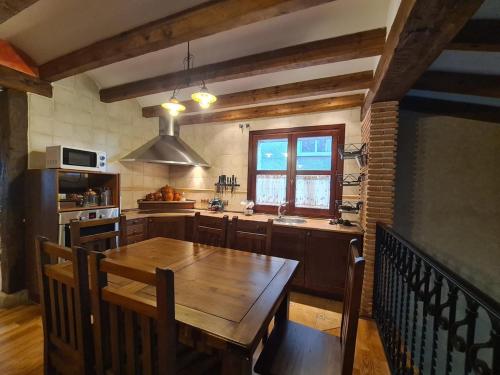 a kitchen with a wooden table and a kitchen with a window at Tu Capricho in Piedralaves