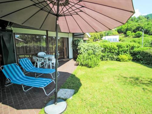 a patio with two chairs and an umbrella at Studio B116 by Interhome in Cissano