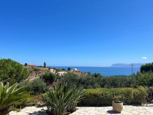 a view of the ocean from a garden with plants at A Casuzza di Poggio Scopello in Scopello