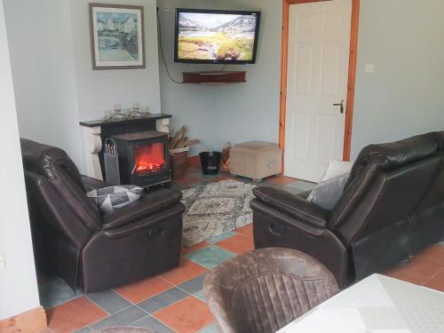 - un salon avec deux fauteuils en cuir et une cheminée dans l'établissement Holiday Home Seamount Holiday Village No 26 by Interhome, à Riverchapel