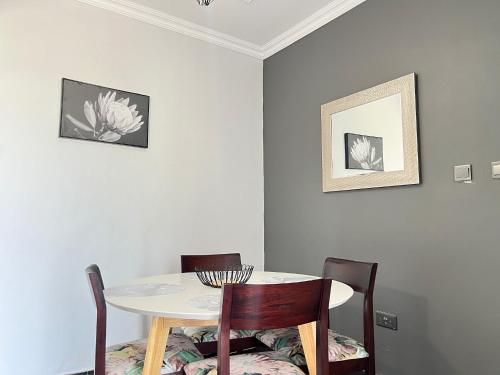a dining room with a table and two chairs at Beauty Blender Homes - The Monotone House in Lilongwe