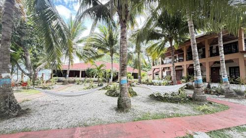 Verandas Beach Resort في Carmen: منتجع فيه أراجيح أمام مبنى