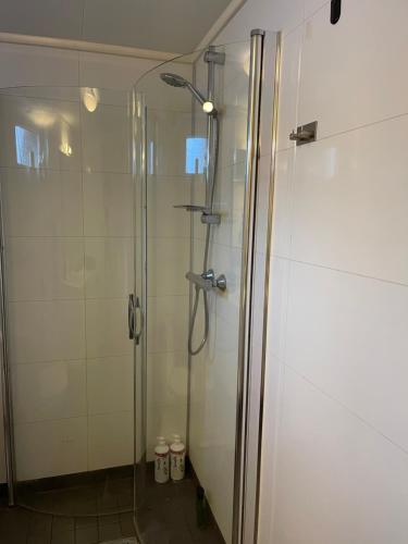 a shower with a glass door in a bathroom at Tromsdalen Studio 2 - FREE Parking, Views & Quiet Area in Trondalen