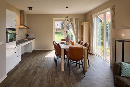 a kitchen and dining room with a table and chairs at Villapark Ehzerburg in Almen