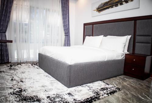 a bedroom with a large bed and a window at Makupula Apartments in Lusaka