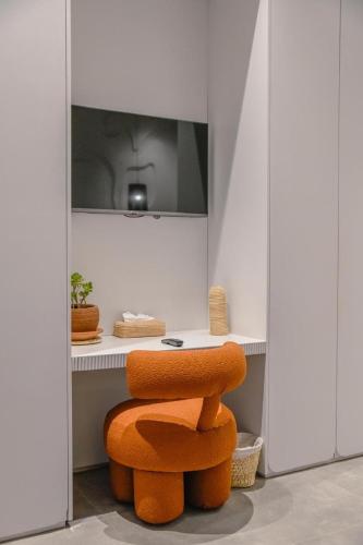 an orange chair in a room with a table at Palais Maya in Id Aïssa