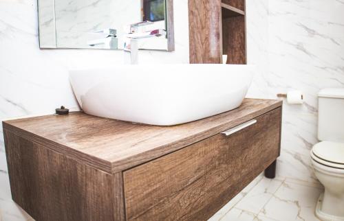 a bathroom with a white sink on a wooden vanity at Makupula Apartments in Lusaka