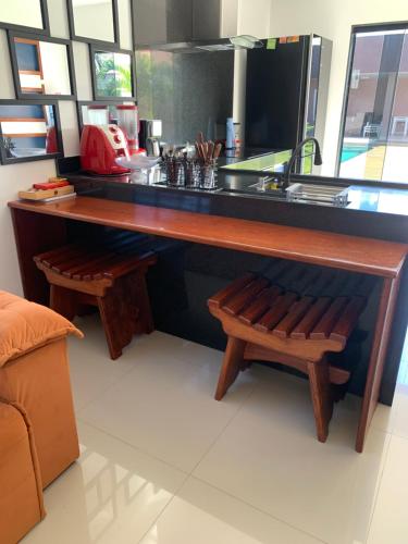a kitchen with a counter with a sink and benches at Faith Home 1 in Arraial do Cabo