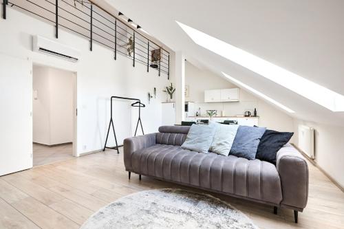 a living room with a couch and a staircase at HONEST Smichov in Prague