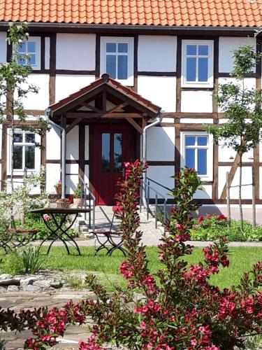 a house with a picnic table and flowers in front of it at Landhaus Weserbergland in Vahlbruch