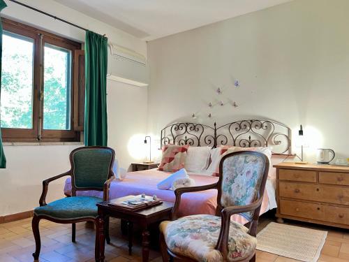 a bedroom with a bed and two chairs and a table at Agriturismo Podere La Fornace in Assisi