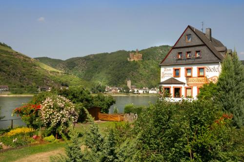 a house on the water next to a lake at Weinhotel Landsknecht in Sankt Goar