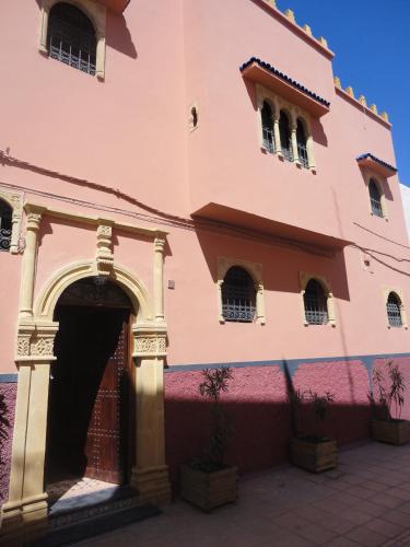 a pink building with an archway in front of it at Dar Yanis in Rabat