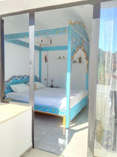 - une chambre avec un lit à baldaquin bleu dans l'établissement Dar houriya, à Tabarka