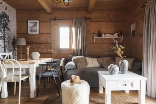 een woonkamer met een bank en een tafel bij Domki w Białce WOODHOUSE- Twój górski azyl przy stoku in Białka Tatrzanska