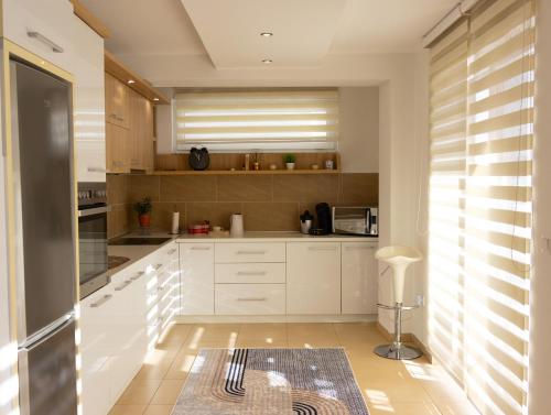 a kitchen with white cabinets and a window at VerdeLuxe Sarajevo in Sarajevo