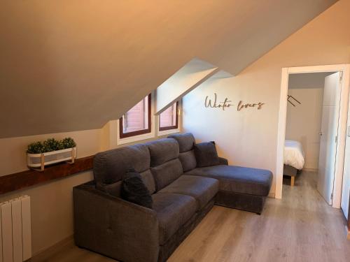 a living room with a couch in a attic at Acogedor Ático en el Corazón de Formigal - Esquía sin llaves in Formigal