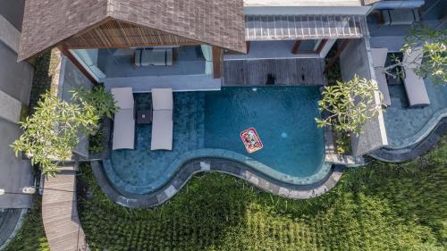 Una vista aérea de una piscina en un edificio. en Queen at Gunung Sari, en Ubud