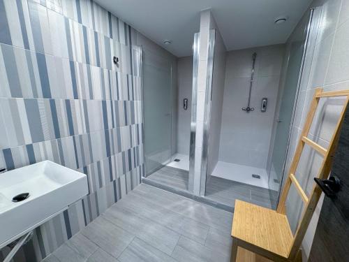 a bathroom with a shower and a white sink at Boliches 71 Hostel in Fuengirola