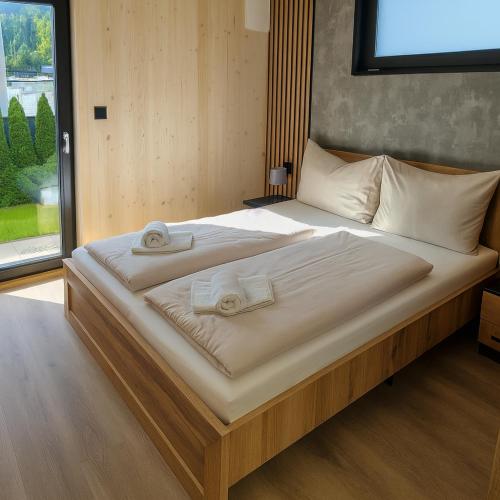 a large bed with two towels on top of it at SMI'S Tiny in Ebensee