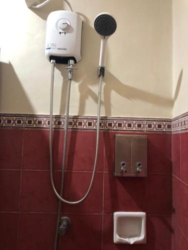 a shower in a bathroom with a hair dryer on the wall at Spacious Modern 4BR Home with 24hr Security and Parking in Cagayan de Oro