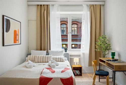 a bedroom with a bed and a desk and a window at Scandi Luxury Renovated Central Access in Helsinki