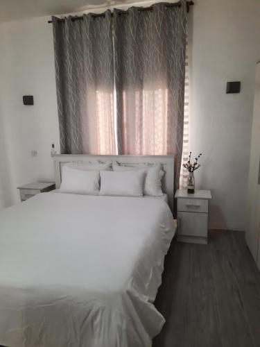 a bedroom with a large white bed with a window at Staycation Wandre in Centre de Flacq