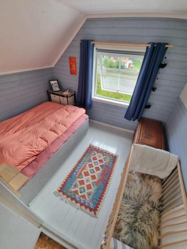 ein kleines Schlafzimmer mit einem Bett und einem Fenster in der Unterkunft Hus i naturskjønne omgivelser in Hopen