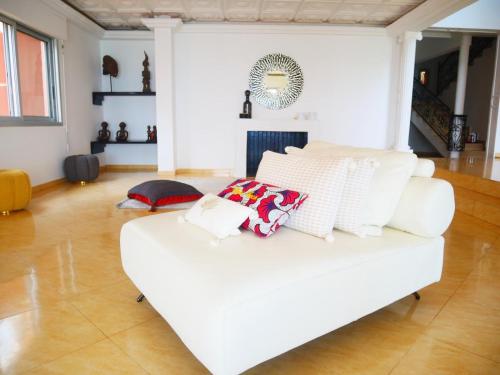 a white couch with pillows on it in a living room at Oasis luxueuse en bord de Mer Virage Dakar in Dakar