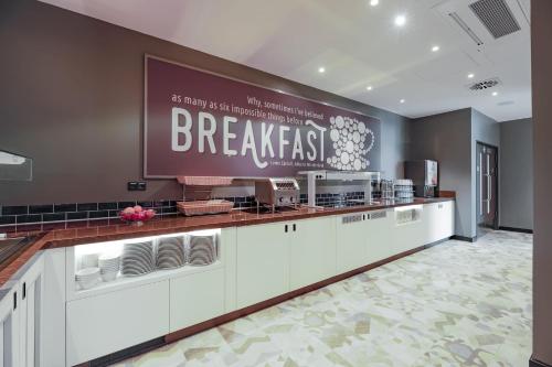 a restaurant with a breakfast counter in a room at Premier Inn Karlsruhe City Am Wasserturm in Karlsruhe