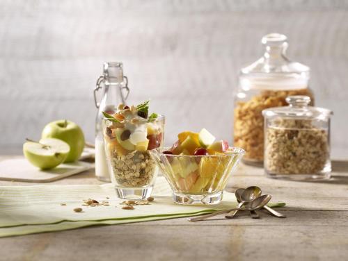 a table with a bowl of fruit and a jar of nuts at Premier Inn Köln City Centre in Cologne