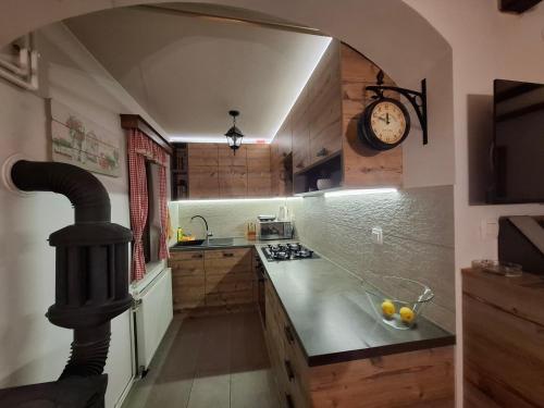 a kitchen with a stove and a clock on the wall at Kuća za odmor HORVAT 