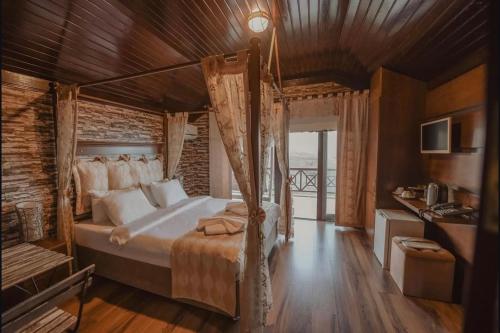 een slaapkamer met een bed met een houten plafond bij Mavisu Deluxe Otel Restaurant in Zafanos