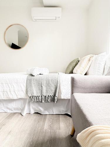 a bedroom with a bed with a mirror on the wall at North Wollongong - Beach Style - Modern - Free Parking - Free Coffee Snacks in Woonona
