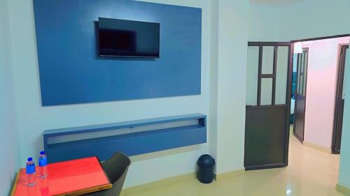 a room with a blue wall with a tv on the wall at Jabulani Lodge in Johannesburg