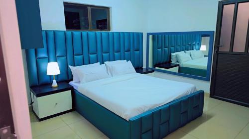 a bedroom with a large bed with a blue headboard at Jabulani Lodge in Johannesburg