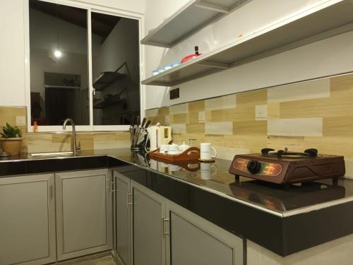a kitchen with a sink and a stove on a counter at Homestead Villa-Polwatta in Welihinda
