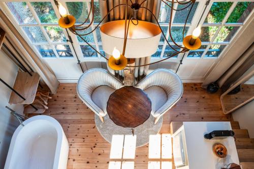 Un baño con una mesa y dos sillas y una lámpara de araña. en Le Parc de Louette - Le Pavillon - Esc'Appart, en Gedinne