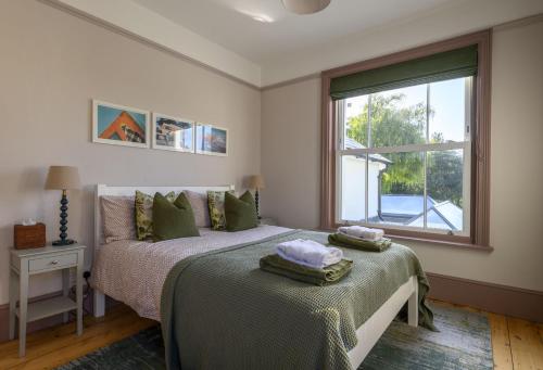 a bedroom with a bed with green sheets and a window at Riverview in Brockenhurst