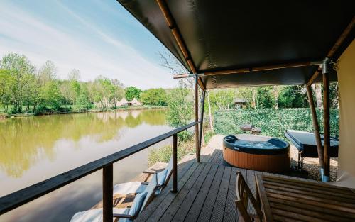 a boat deck with a hot tub and chairs at Kingfisher Safari Tent in Droitwich