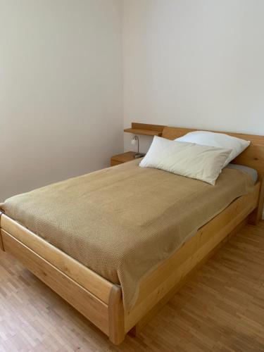 a bed with a wooden frame and a pillow on it at Ferienwohnung Summerset 2 in Rosengarten