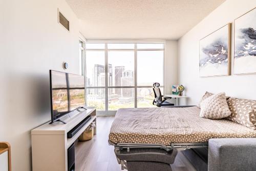 a bedroom with a bed and a large window at CN Luxury Suites - Complementary Parking - Save on MONTHLY STAYS in Toronto