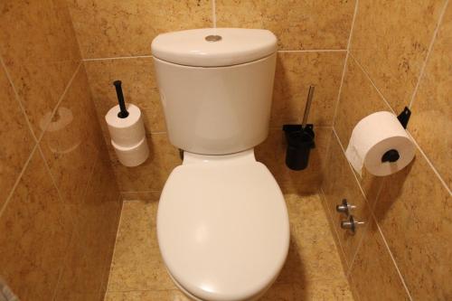 eine weiße Toilette in einem Badezimmer mit zwei Rollen Toilettenpapier in der Unterkunft SixtyNine Beach Cottage in Torreira