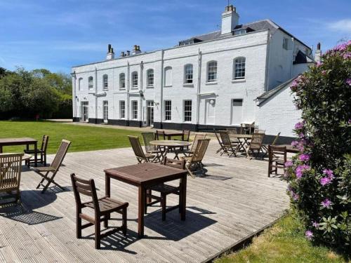 a group of tables and chairs in front of a white building at The Retreat New Forest in Christchurch
