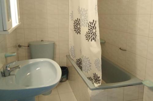 ein Badezimmer mit Waschbecken, Toilette und Duschvorhang in der Unterkunft 3 Bed House Sleeps 6 with Pet-Friendly Garden in Corme-Puerto